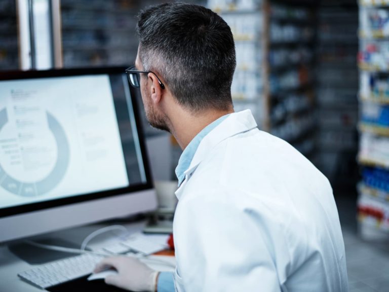 Scientist at computer for aseptic fill finish manufacturing