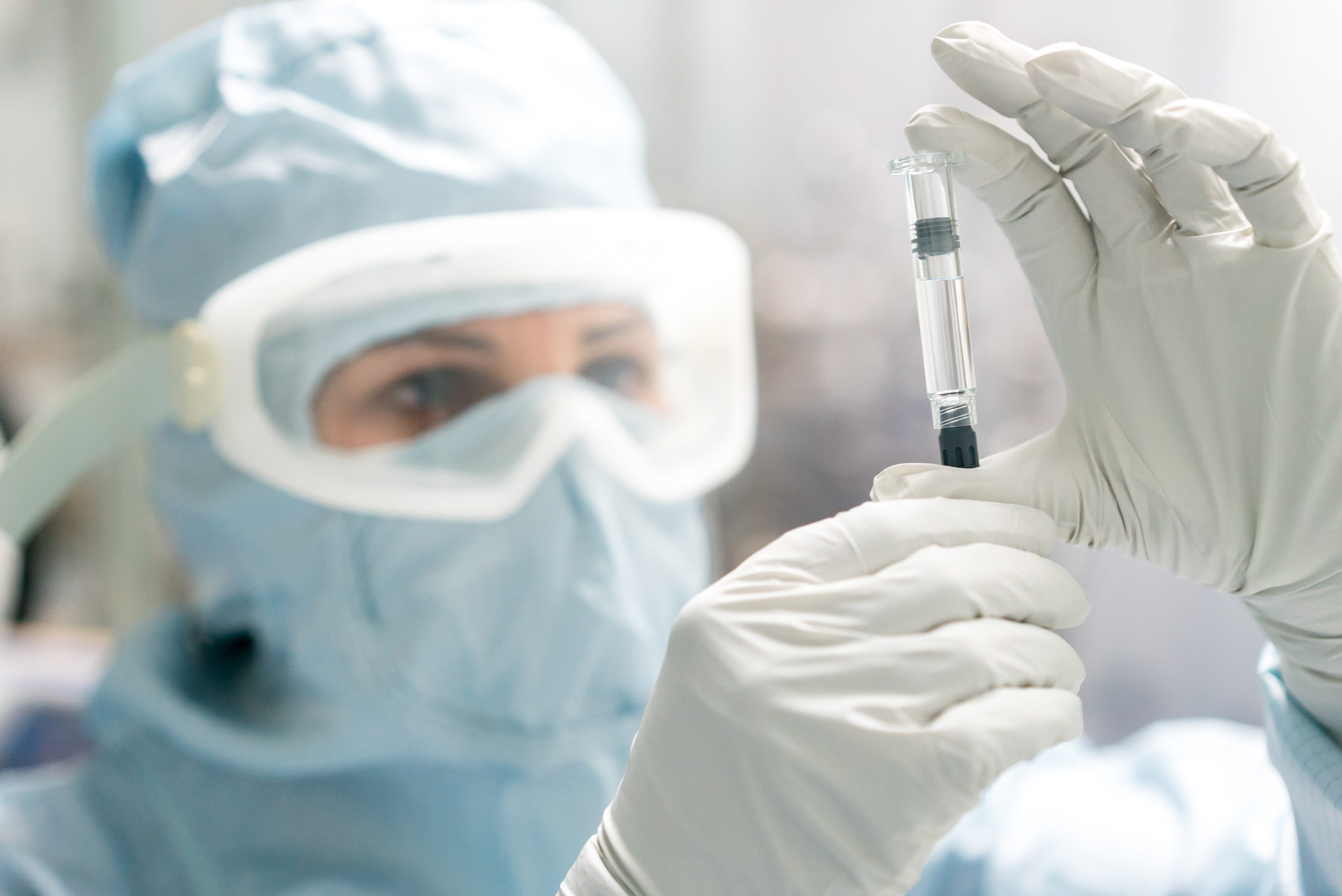 Technician inspecting pre-filled syringe
